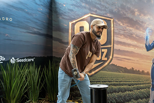Visitantes participam do desafio Martelo da Força no estande da Verluz durante a Showtec 2026 tentando alcançar o Vigor 99.