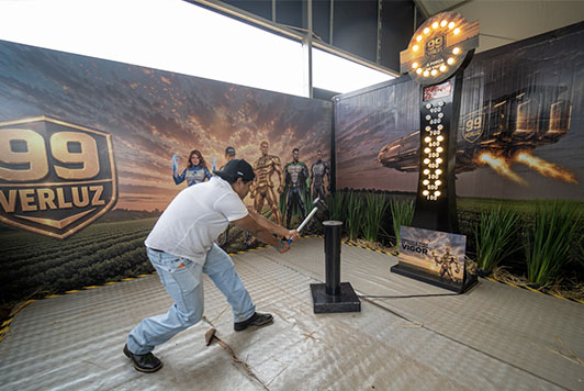 Visitantes participam do desafio Martelo da Força no estande da Verluz durante a Showtec 2026 tentando alcançar o Vigor 99.