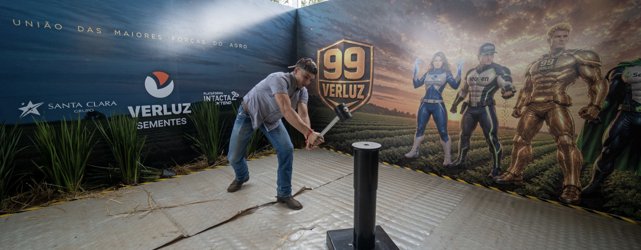 Visitantes participam do desafio Martelo da Força no estande da Verluz durante a Showtec 2026 tentando alcançar o Vigor 99.